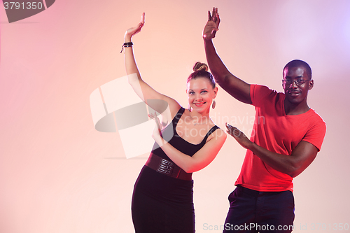 Image of The young cool black man and white woman is dancing