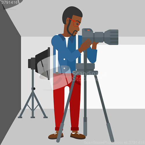 Image of Photographer working with camera on a tripod.