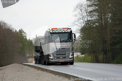 Image of Bronze Volvo FH16 650 Combination Truck on the Road