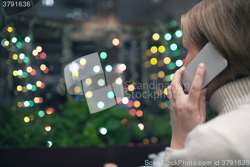 Image of Woman in cafe talking on the phone