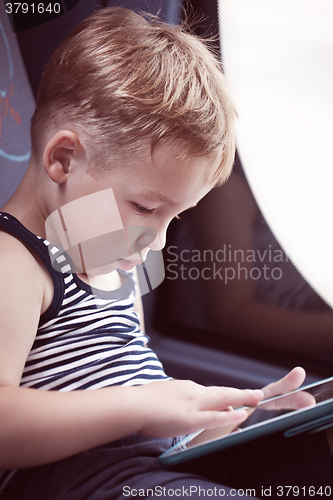 Image of Little child using touch pad while traveling by bus