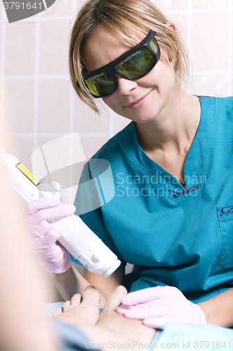 Image of Smiling practitioner doing a laser treatment