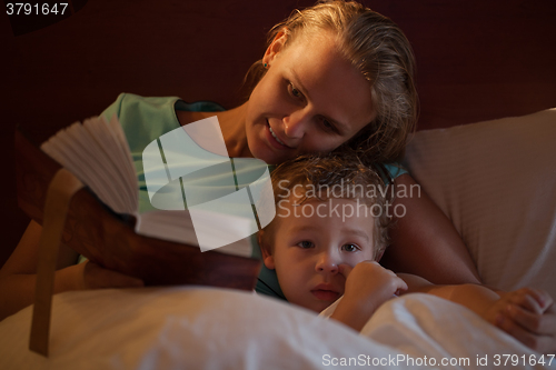 Image of Mother reading a bedtime story to her little son