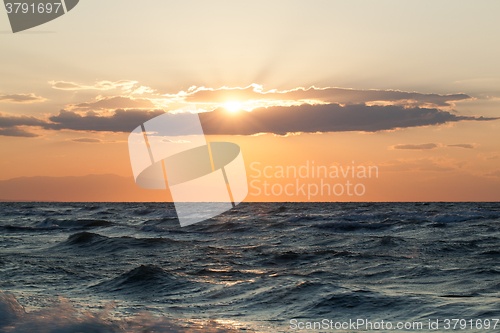 Image of Rough sea and sunset over it