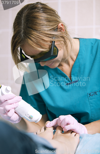 Image of Doctor doing a laser treatment on womans foot