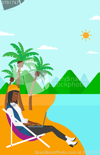 Image of Business woman sitting in chaise lounge with laptop.