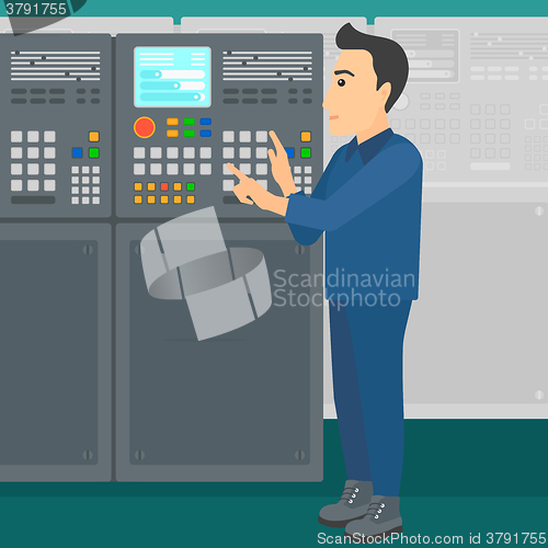 Image of Engineer standing near control panel.