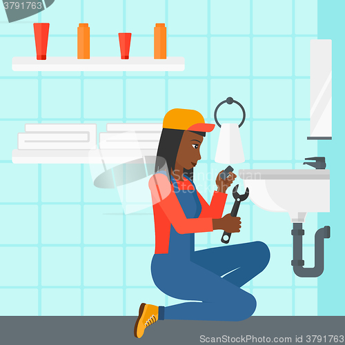 Image of Woman repairing sink.