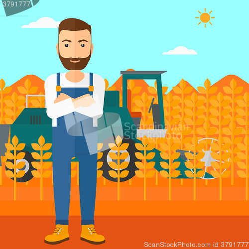 Image of Man standing with combine on background.