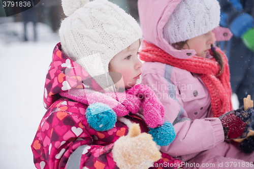 Image of portrait of two little girls sitting together on sledges