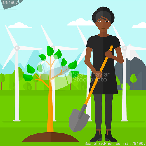 Image of Woman plants tree.