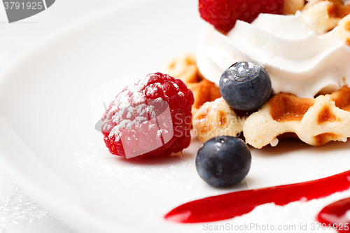 Image of Golden waffle served with cream and berries