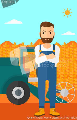 Image of Man standing with combine on background.