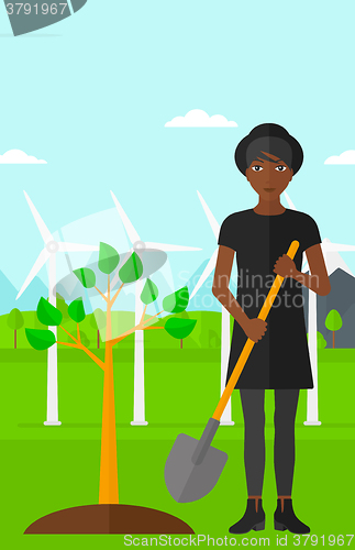 Image of Woman plants tree.