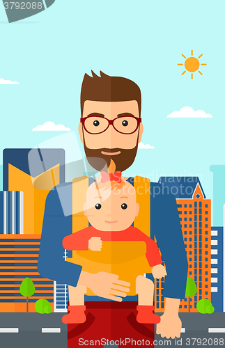 Image of Man holding baby in sling.