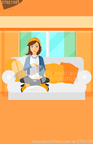 Image of Pregnant woman sitting on sofa.