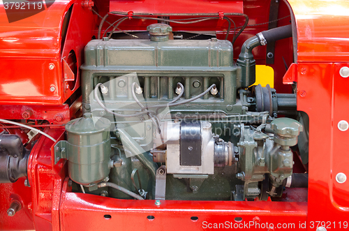 Image of a green diesel engine i a red tractor