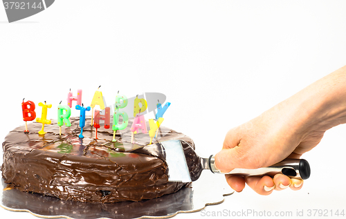 Image of Female person cutting a homemade sacher chocolate cake with birt