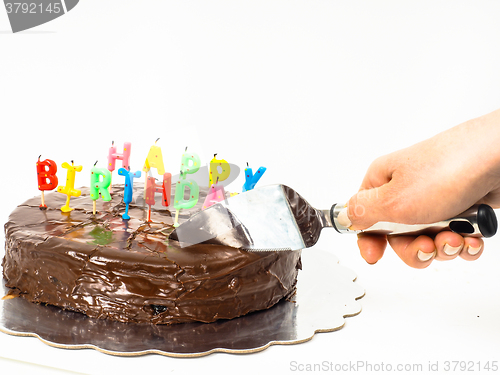 Image of Female person cutting a homemade sacher chocolate cake with birt