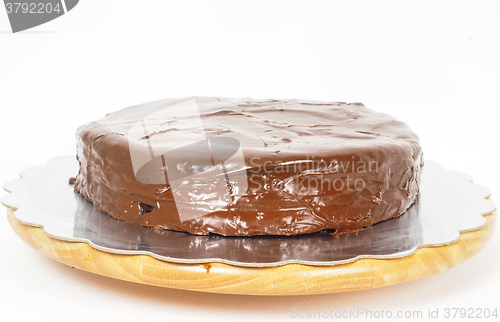 Image of Sacher chocolate cake on a silver plate on wooden board towards 