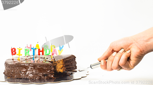 Image of Female person serving a homemade sacher chocolate cake with birt