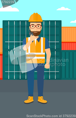 Image of Stevedore standing on cargo containers background.