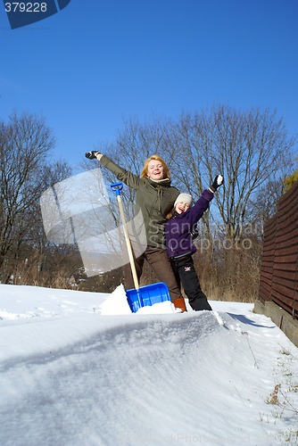 Image of mother and her daughter throw up snow on a winter background