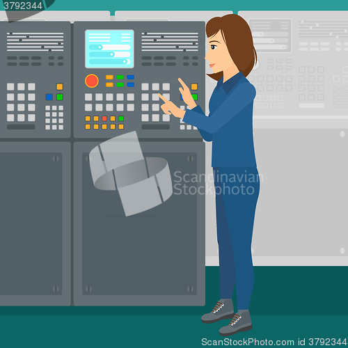 Image of Engineer standing near control panel.