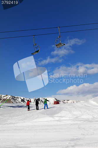 Image of Three skiers on slope at sun day