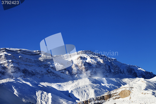 Image of Snowy mountains at sun windy day