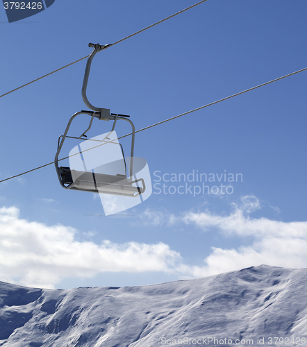 Image of Chair lift and snowy mountains at nice day