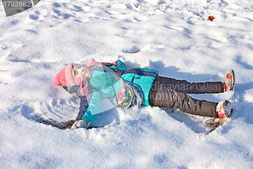 Image of Little girl lying on a snow