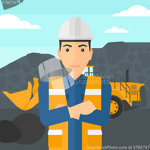 Image of Miner with mining equipment on background.