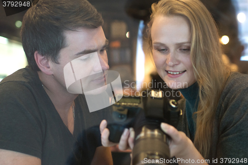 Image of Young people looking through the photos on camera