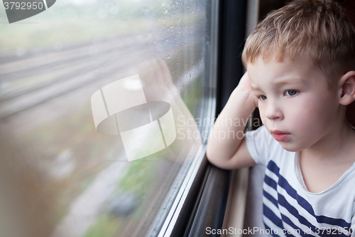 Image of Boy looking out the window of train