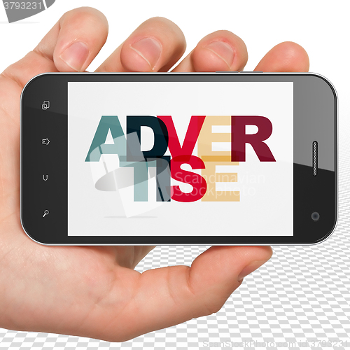 Image of Marketing concept: Hand Holding Smartphone with Advertise on  display