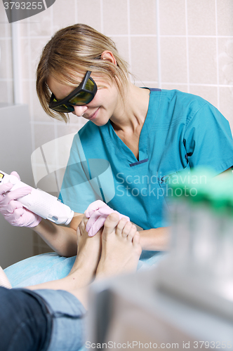 Image of Podiatrist doing a foot laser treatment