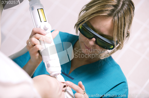 Image of Beautician doing laser skin treatment