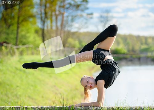 Image of Rhythmic gymnast girl exercising with ribbon outdoor