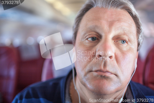 Image of Man listening to music in the airplane