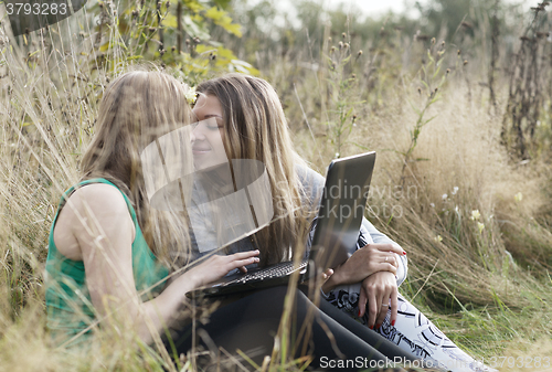 Image of Two women friends sitting outdoors together