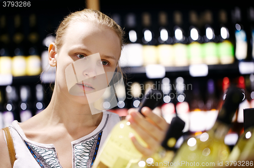 Image of Woman shopping for alcohol in a bottle store