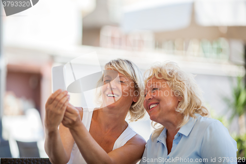 Image of Happy senior women making mobile selfie