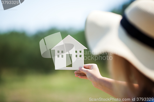 Image of Woman holding house model in the countryside