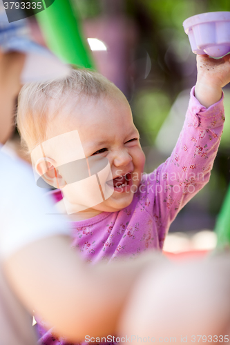 Image of Laughing little baby playing with a toy