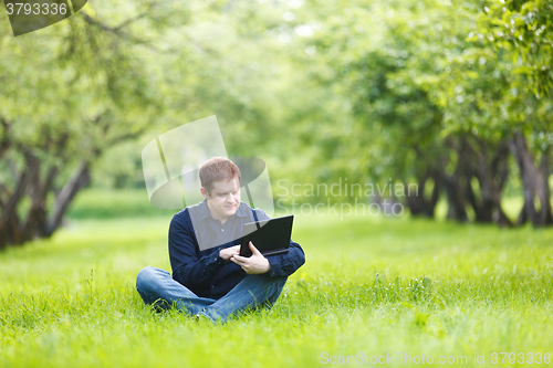 Image of Man working with notebook in the park.