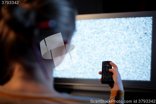 Image of Woman with remote control in front of TV set