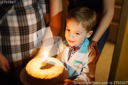 Image of Little boy carrying birthday cake