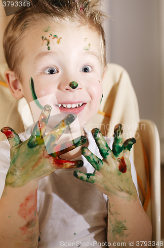 Image of Cute excited boy with hands full of finger paint