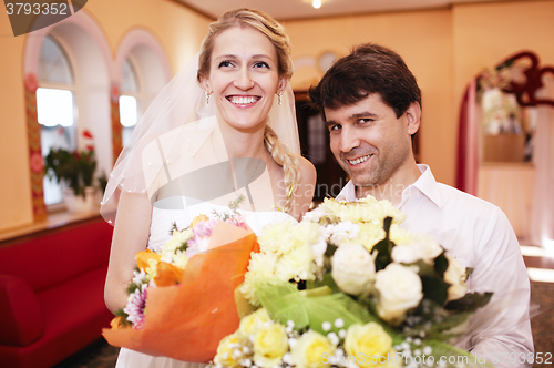 Image of Smiling bride and groom with bouquets of flowers